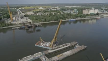 Fotókon Magyarország legnagyobb beruházása: kulcspillanathoz ért a mohácsi Duna-híd építése, leállították a hajóforgalmat – beemelték a betonszörnyet a mederbe